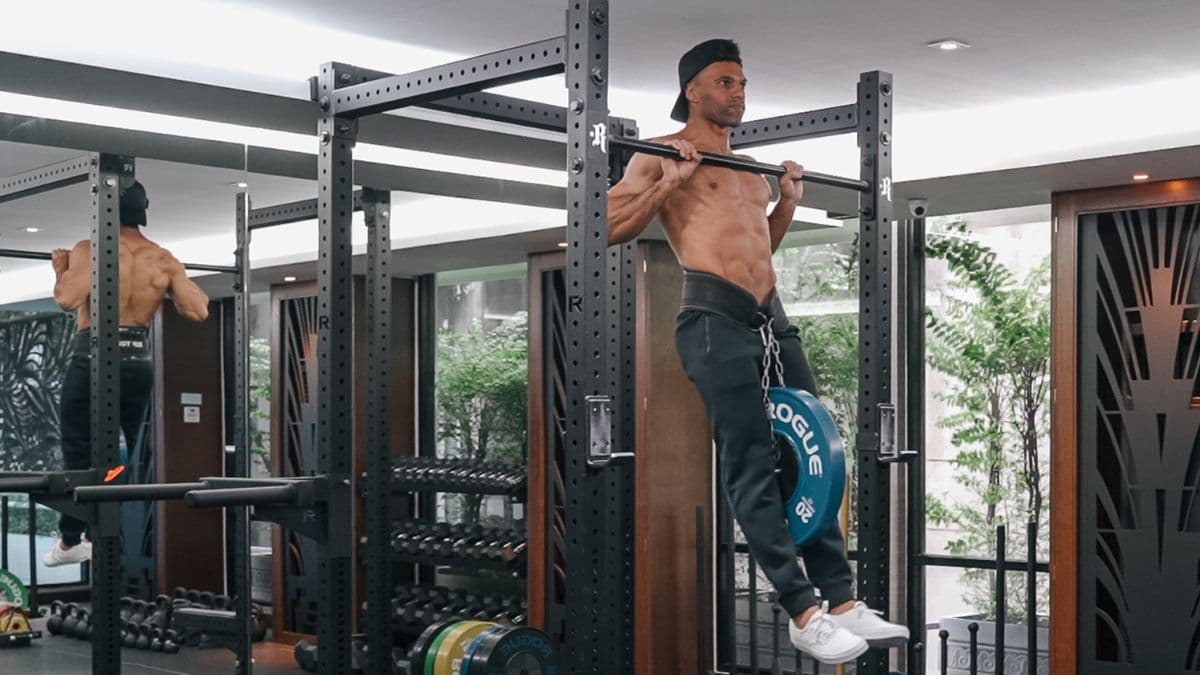 Kemo Marriott doing a weighted pull-up with a plate on a dip belt